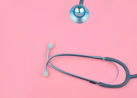 Still image of one single normal stethoscope isolated on top of a pink color Stock Photos