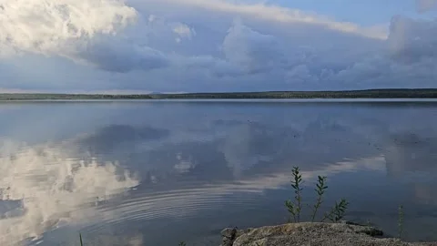Still lake surface reflecting dramatic clouds Stock Footage 306180642
