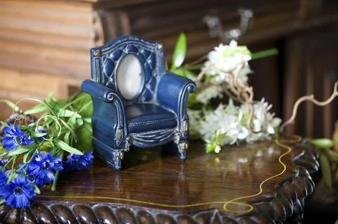 Still life with antique frame in the shape of a chair and flowers Stock Photos