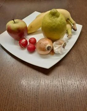 Still life composition featuring a mix of fresh fruits and vegetables arranged Stock Photos