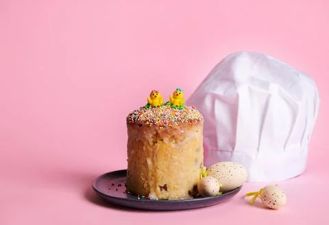 Still life. Easter bread, eggs and white chef's hat on pink background 스톡 사진