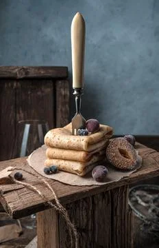 Still life with a fork stuck in a stack of pancakes with berries on a high Foto stock