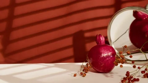 Still life with grapefruit, mirror cube, vase with dried flowers, red cloth with Stock Footage 197812208