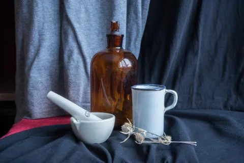 Still life with a mortar, an old bottle and a measuring cup for chemistry Stock Photos