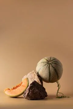 Still life with nature objects. Melon and stones on beige background. Creativ Stock Photos