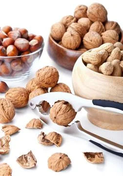 Still life with nuts and nutcracker on white Stock Photos