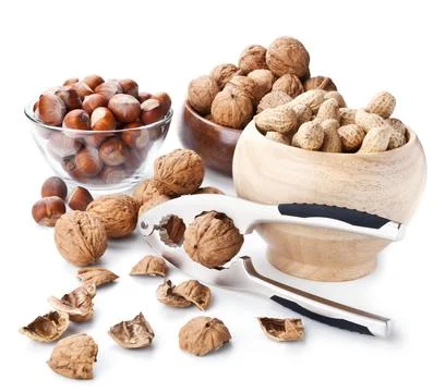 Still life with nuts and nutcracker on white Stock Photos