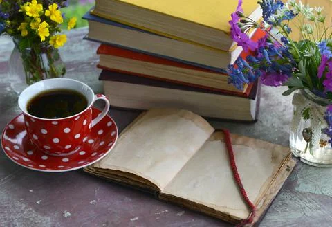 Still life with open diary with empty pages, cup of tea and pile of books wit Foto stock
