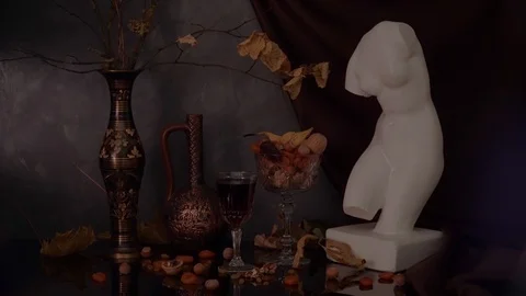 Still life with a plaster bust of Venus on a background of drapery, branches wit Video stock 121057751