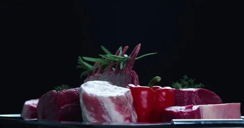 Still life raw meat pieces composition rotation 4k looped video black background Stock Footage 70198054