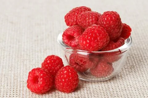 Still life with red raspberry and glass bowl on gray linen table cloth, copy  Stock Photos