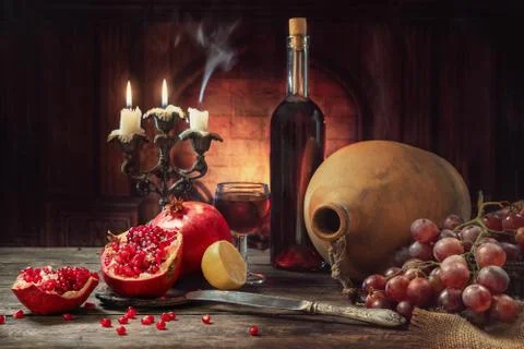 Still life in a rustic style. Fruit-pomegranates, grapes and lemon lying on a Stock Photos