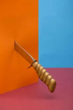Still life with a sharp knife piercing an orange object Stock Photos