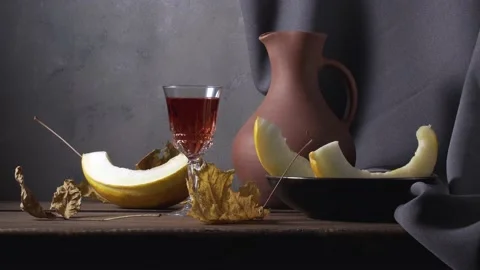 Still life with sliced melon, a clay jug of wine and autumn leaves Stock Footage 138637686