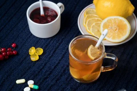 Still life of tea with lemon, tablets and thermometer, jam and berries. The c Stock Photos