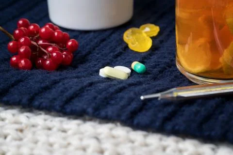 Still life of tea with lemon, tablets and thermometer, jam and berries. The c Stock Photos