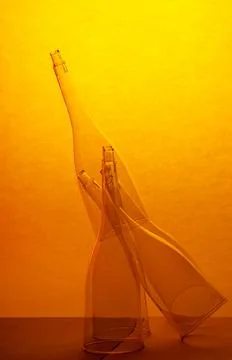 Still life with transparent empty glasses on a yellow-orange background Stock Photos