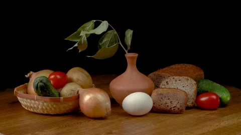 Still life with vegetables and bread on a black background. Stock Footage 159469926