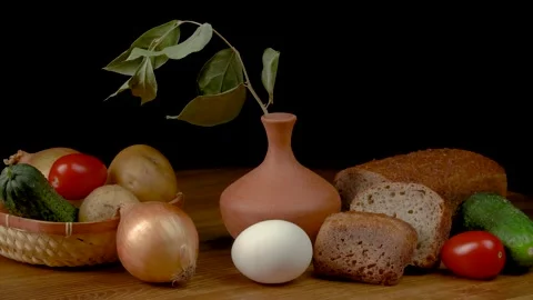 Still life with vegetables and bread on a black background. 動画素材 159535848