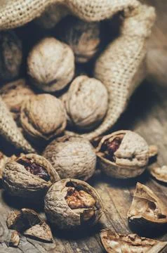 Still life with walnuts and cracked shells in vintage burlap bag. Stock-Fotos
