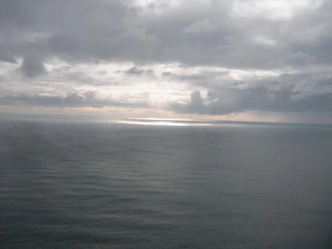 Still ocean with sun rays through cloud 写真素材