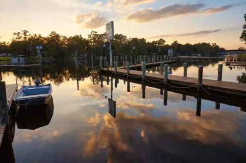 Still river reflections off of dock Stock Photos