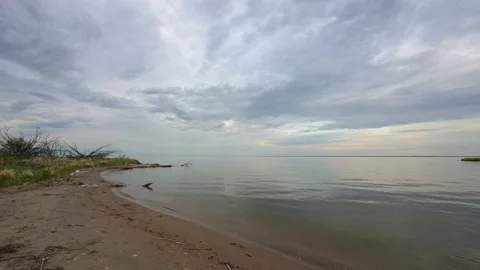 Still setup on a small sandy beach next to a calm very large lake  Stock Footage 234579379