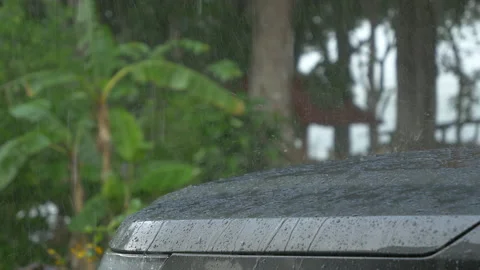 STILL SHOT, CLOSE UP: Pouring rain and bouncing raindrops on the gray car hood Stock Footage 190129039
