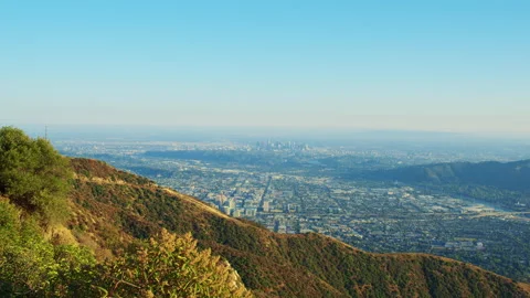 A still shot with the edge of a green mountain and the cityscape of Los Angeles  Stock Footage 282000716