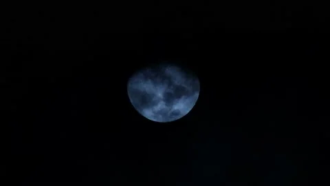 A still shot of the full moon in a night sky with clouds passing in front Vidéo 237944952
