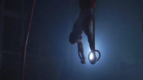 A Still shot of a guy working out on the still rings a gymnastics apparatus that Stock Footage 101489998