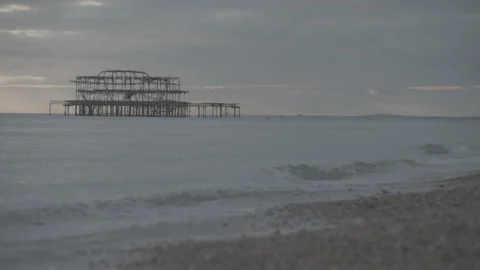 Still shot of old metal structure in ocean, waves on shoreline Stock Footage 202133469