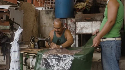 Still shot of two Cuban men working in workshop with sewing machine, Cuba Stock-Footage 141666497