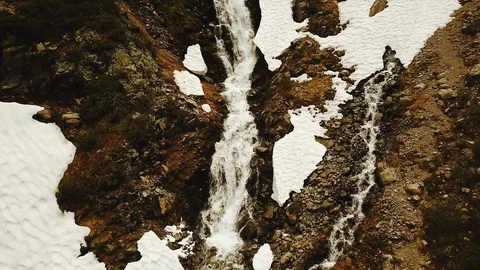 Still shot of wild mountain stream running over rocks and snow Stock Footage 116325306