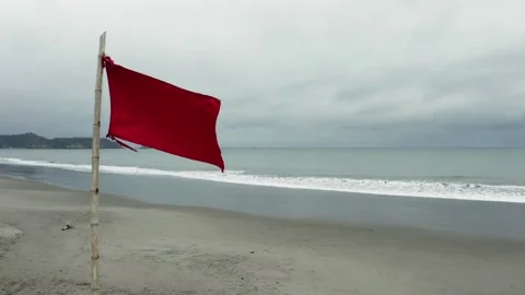 Still video of a red flag on the beach alongside a lifeguard post Stock Footage 146344362