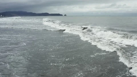 Still video showing the small waves of the Pacific Ocean running into the beach Stock Footage 146345245