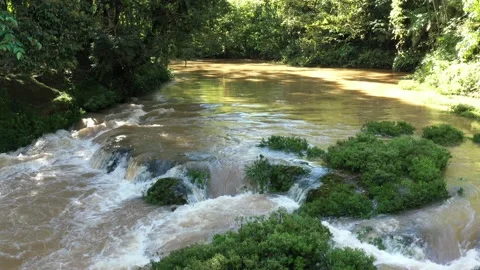 Still video of a small cascade showing the brown water running quickly with Stock Footage 142748668