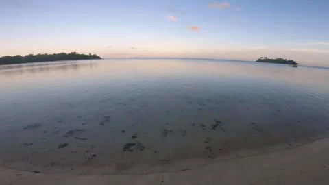 Still view beach side during low tide sunset time with ocean water reflection to Stock Footage 252179323