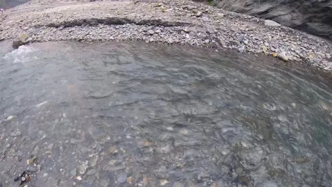 Still view look of shallow fast flowing river water with pile of gravel rock sto Stock Footage 266501797