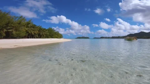 Still view of shallow calm lagoon look out to white sandy beach to empty tourist Stock Footage 250402359