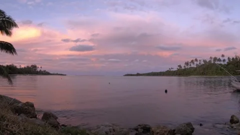 Still view of sunset at a harbor with reddish pink sky and light wave tumbling o Stock Footage 235314990