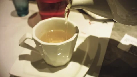 Still view of teapot pouring tea animation action movement in to a white cup mad Stock Footage 236292610