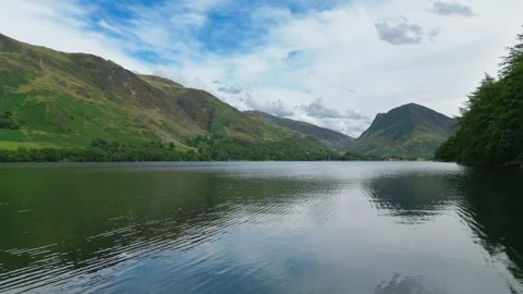 Still water mirrors distant green hills Stock Footage 345523213