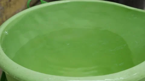 Still Water Surface in a Filled Plastic Bucket After the Water Flow Stops Close Stock Footage 341869264