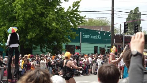 Stilt walker and clown parade performers in Seattle street procession Stock Footage 339036396