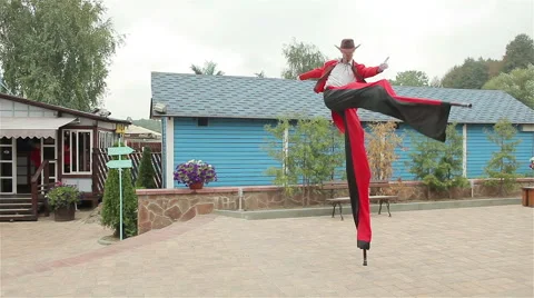 Stilt walker in red costium dancing and running Video stock 46003433