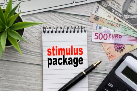 STIMULUS PACKAGE text with notepad, keyboard, decorative vase, fountain pen  库存照片