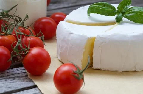 Stinky French cheese and red cherry tomatoes. Closeup Stock Photos