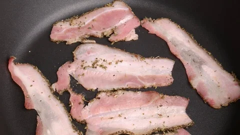 Stir bacon in a frying pan. Stock Footage 70878859