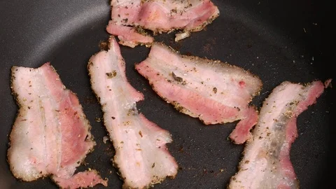 Stir bacon in a frying pan. Stock Footage 70879134